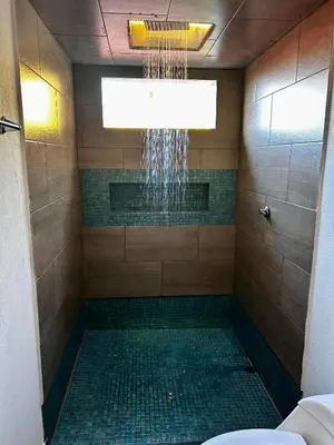 a bathroom with a shower with a toilet and a chandelier at Cabaña Cedro Amarillo - Jacuzzi Grande Con Calefacción - Cerca a Medellín in Sopetran