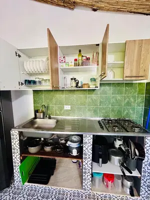a small kitchen with a sink and a stove at Cabaña Cedro Amarillo - Jacuzzi Grande Con Calefacción - Cerca a Medellín in Sopetran