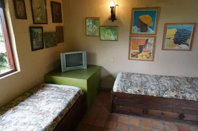 a room with two beds and a tv on the wall at Casa Familiar y Naturaleza en Parcelación Privada in Amagá