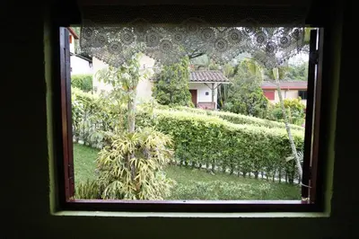 a window with a view of a garden and a house at Casa Familiar y Naturaleza en Parcelación Privada in Amagá