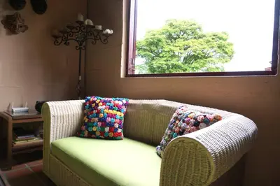 a couch with pillows on it in a room with a window at Casa Familiar y Naturaleza en Parcelación Privada in Amagá
