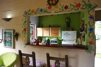 a kitchen with a green wall with a shelf at Casa Familiar y Naturaleza en Parcelación Privada in Amagá