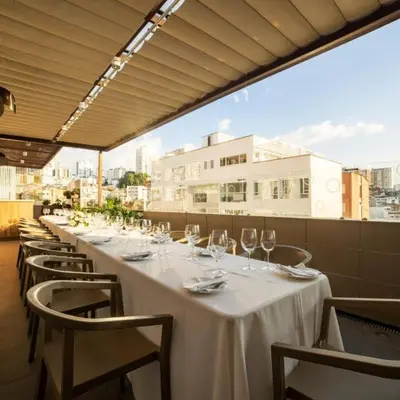 a long table with chairs and wine glasses on a rooftop at Quo Quality Hotel in Manizales