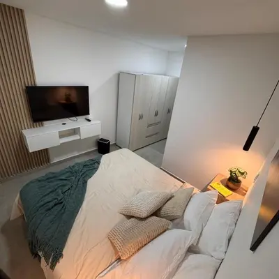 a bedroom with a bed with a tv on the wall at Apartamentos con vista boscosa y parking en Buenos Aires, Medellín in Medellín