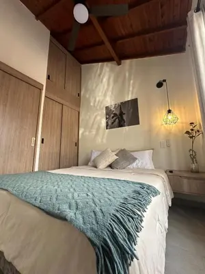 a bedroom with a bed with a green blanket at Apartamentos con vista boscosa y parking en Buenos Aires, Medellín in Medellín
