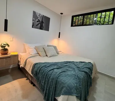 a bedroom with a bed and two windows at Apartamentos con vista boscosa y parking en Buenos Aires, Medellín in Medellín