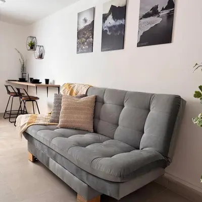 a gray couch in a living room with a table at Apartamentos con vista boscosa y parking en Buenos Aires, Medellín in Medellín