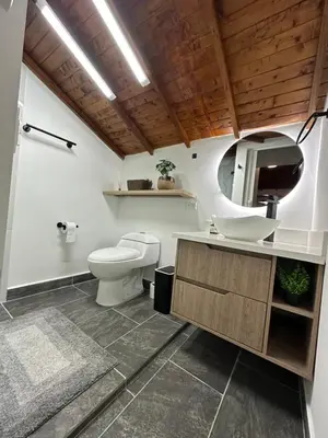 a bathroom with a toilet and a sink and a mirror at Apartamentos con vista boscosa y parking en Buenos Aires, Medellín in Medellín