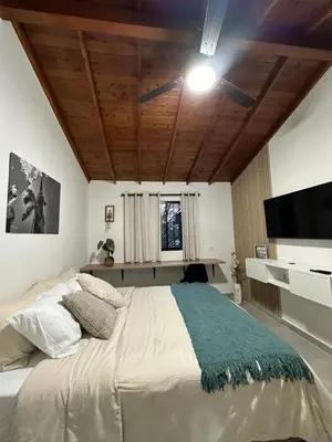 a bedroom with a large bed with a ceiling fan at Apartamentos con vista boscosa y parking en Buenos Aires, Medellín in Medellín