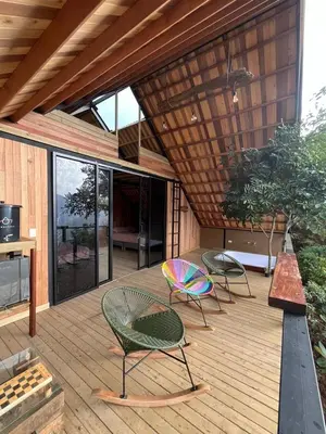 two chairs and a table on a wooden deck at Tambo 3 Carriquí - Reserva Natural Salto del Buey in Montebello