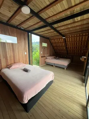 a bedroom with two beds in a wooden room at Tambo 3 Carriquí - Reserva Natural Salto del Buey in Montebello