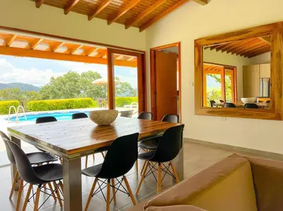 a dining room with a wooden table and chairs at 15 mins to Jardín Spacious & Convenient House in Los Andes