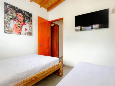 a bedroom with a bed and a flat screen tv at 15 mins to Jardín Spacious & Convenient House in Los Andes