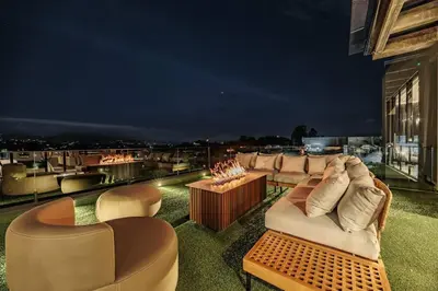 a rooftop patio with couches and a table with fires at Luxurious Farm House in Rionegro