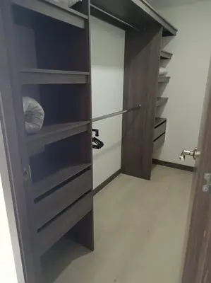 a walk in closet with wooden shelves and a door at Oasis urbano, cerca a todo, a una cuadra del metro in Sabaneta