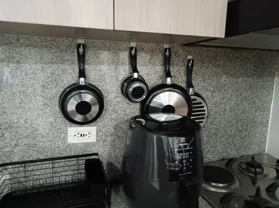 three pots and pans hanging on a kitchen counter at Oasis urbano, cerca a todo, a una cuadra del metro in Sabaneta