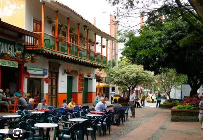 a group of people sitting at tables outside a building at Oasis urbano, cerca a todo, a una cuadra del metro in Sabaneta