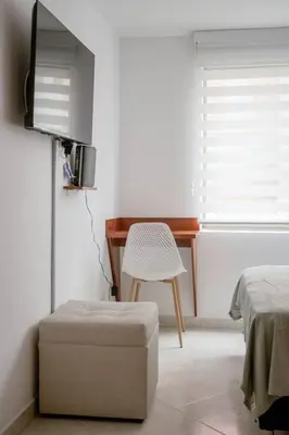 a room with a desk and a television and a chair at Crisalida Apartamento in Sabaneta
