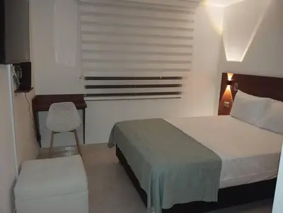a bedroom with a bed and a desk and a chair at Crisalida Apartamento in Sabaneta