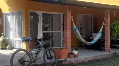 a bike parked in front of a house with hammocks at Casa de la Cruz in Mariquita