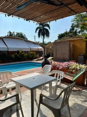 a patio with a table and chairs next to a pool at Casa de la Cruz in Mariquita