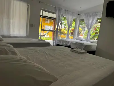 a bedroom with two beds and a window at Casa de la Cruz in Mariquita