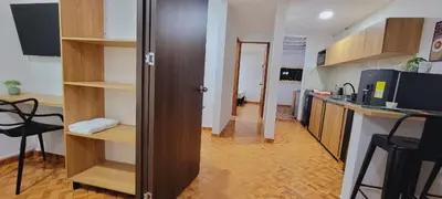 a room with a kitchen with wooden shelves and a kitchen at Luxury Room San Nicolás Mall in Rionegro