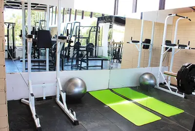 a gym with several treadmills and exercise equipment at Beverly Hills Mansion room only in Guarne