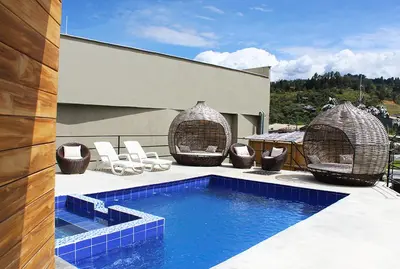a house with a swimming pool and chairs and a building at Beverly Hills Mansion room only in Guarne