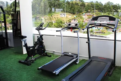 a room with two exercise bikes and a window at Beverly Hills Mansion room only in Guarne