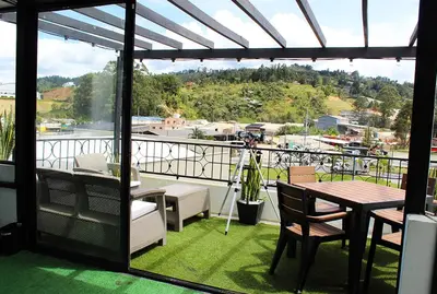 a patio with a table and chairs on a balcony at Beverly Hills Mansion room only in Guarne