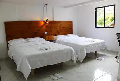 a bedroom with two beds with white sheets at Beverly Hills Mansion room only in Guarne