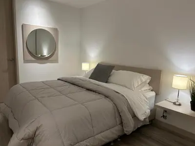 a bedroom with a large bed and a mirror at Apartamento Exclusivo Manizales in Manizales