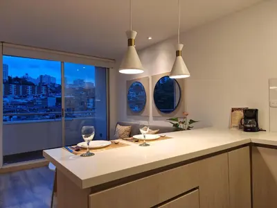 a kitchen with two wine glasses and a window at Apartamento Exclusivo Manizales in Manizales
