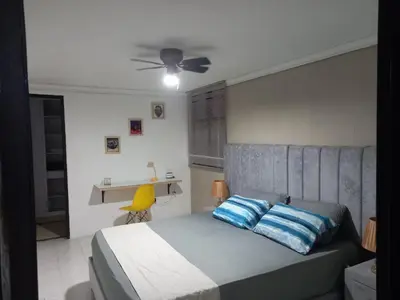 a bedroom with a bed with blue and white pillows at apartamento 3 habitaciones cerca al parque del poblado in Medellín