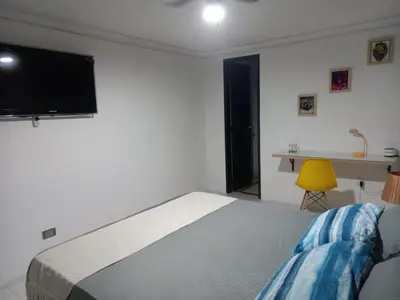 a bedroom with a bed and a flat screen tv at apartamento 3 habitaciones cerca al parque del poblado in Medellín