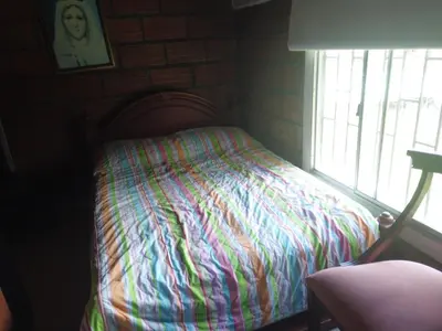 a bed with a colorful blanket in a room with a window at Casa de campo barbosa Antioquia in Barbosa