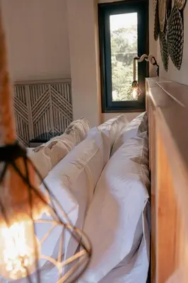 a bed with white pillows in a room with a window at La Gracia Hotel & Spa in San Jerónimo