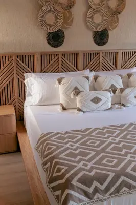 a bedroom with a bed with white sheets and pillows at La Gracia Hotel & Spa in San Jerónimo