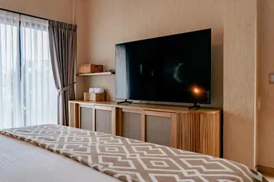 a bedroom with a flat screen tv and a bed at La Gracia Hotel & Spa in San Jerónimo