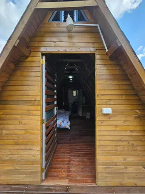 an open door of a wooden cabin with a bed at Reserva Natural Maimará in Alejandría