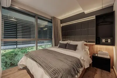 a bedroom with a large bed and a large window at H10 - Provenza in Medellín