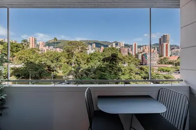 a table and chair in front of a window with a view at H10 - Provenza in Medellín