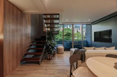 a living room with a spiral staircase in a house at H10 - Provenza in Medellín
