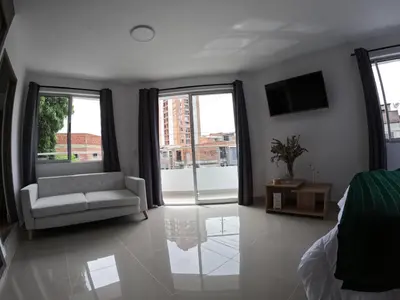 a living room with a couch and a tv at Hermoso Loft cerca al poblado y al metro in Medellín