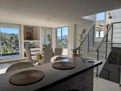 a living room with a table and chairs at Mountain Home Close to Guatape Pueblo With Jacuzzi in Guatapé