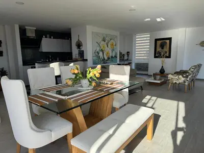 a dining room with a glass table and white chairs at Mountain Home Close to Guatape Pueblo With Jacuzzi in Guatapé