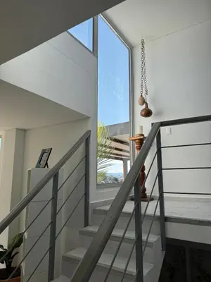 a staircase in a house with a large window at Mountain Home Close to Guatape Pueblo With Jacuzzi in Guatapé
