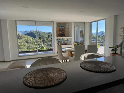 a dining room with a table and chairs with a view at Mountain Home Close to Guatape Pueblo With Jacuzzi in Guatapé