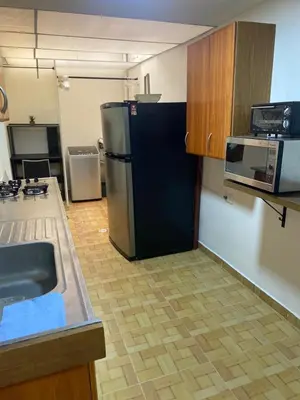 a kitchen with a black refrigerator and a microwave at Acogedor loft, para 4 huéspedes Medellín Antioquia in Medellín
